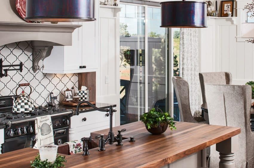Elegant kitchen with wooden countertop, black and white stove, and overhead lighting.