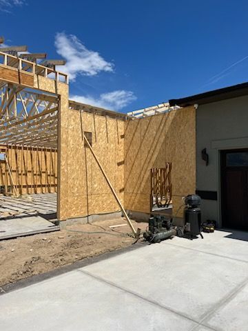 Construction site: framing of a new building with exposed wooden walls and blue sky.