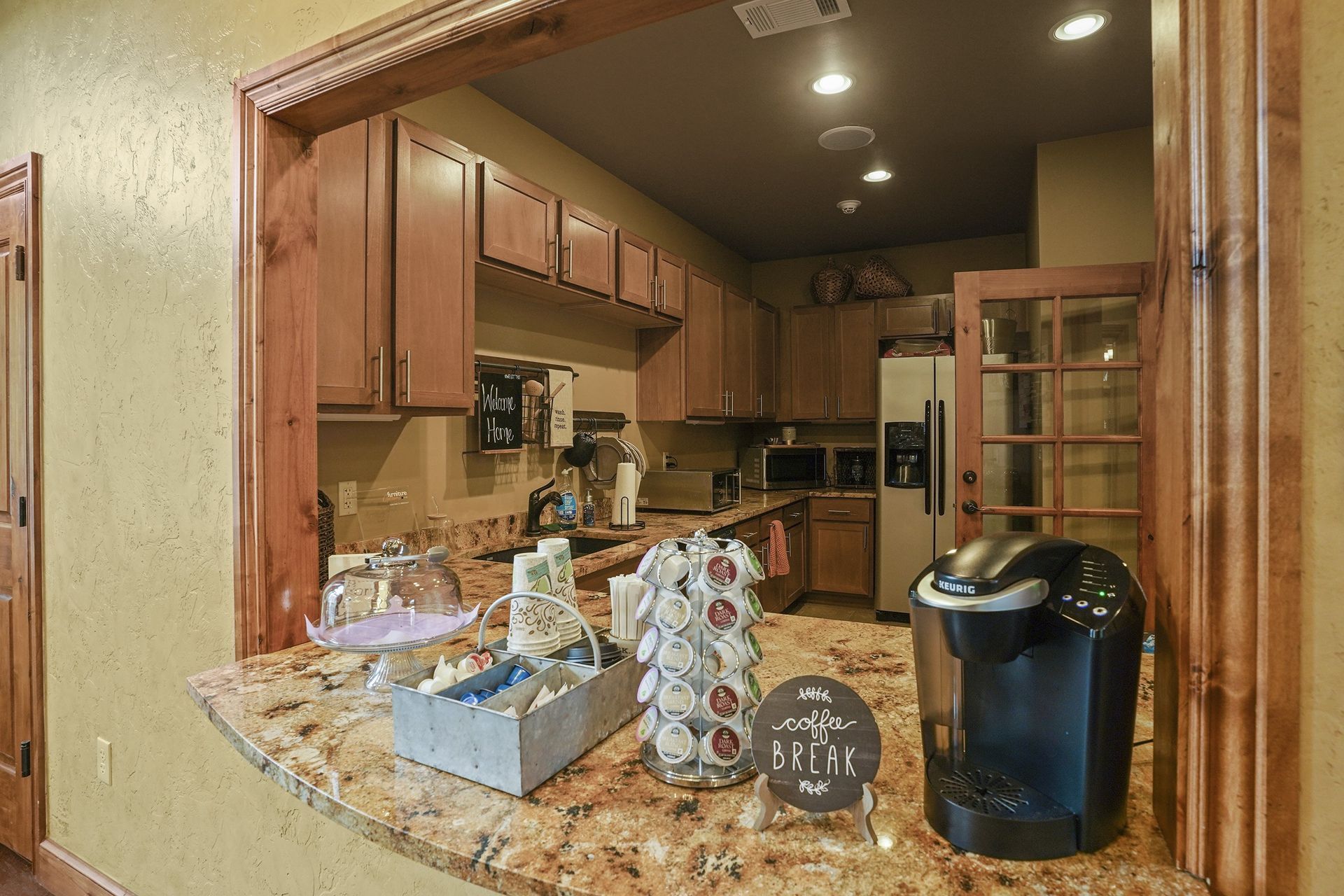 A kitchen with a coffee maker and a sign that says 