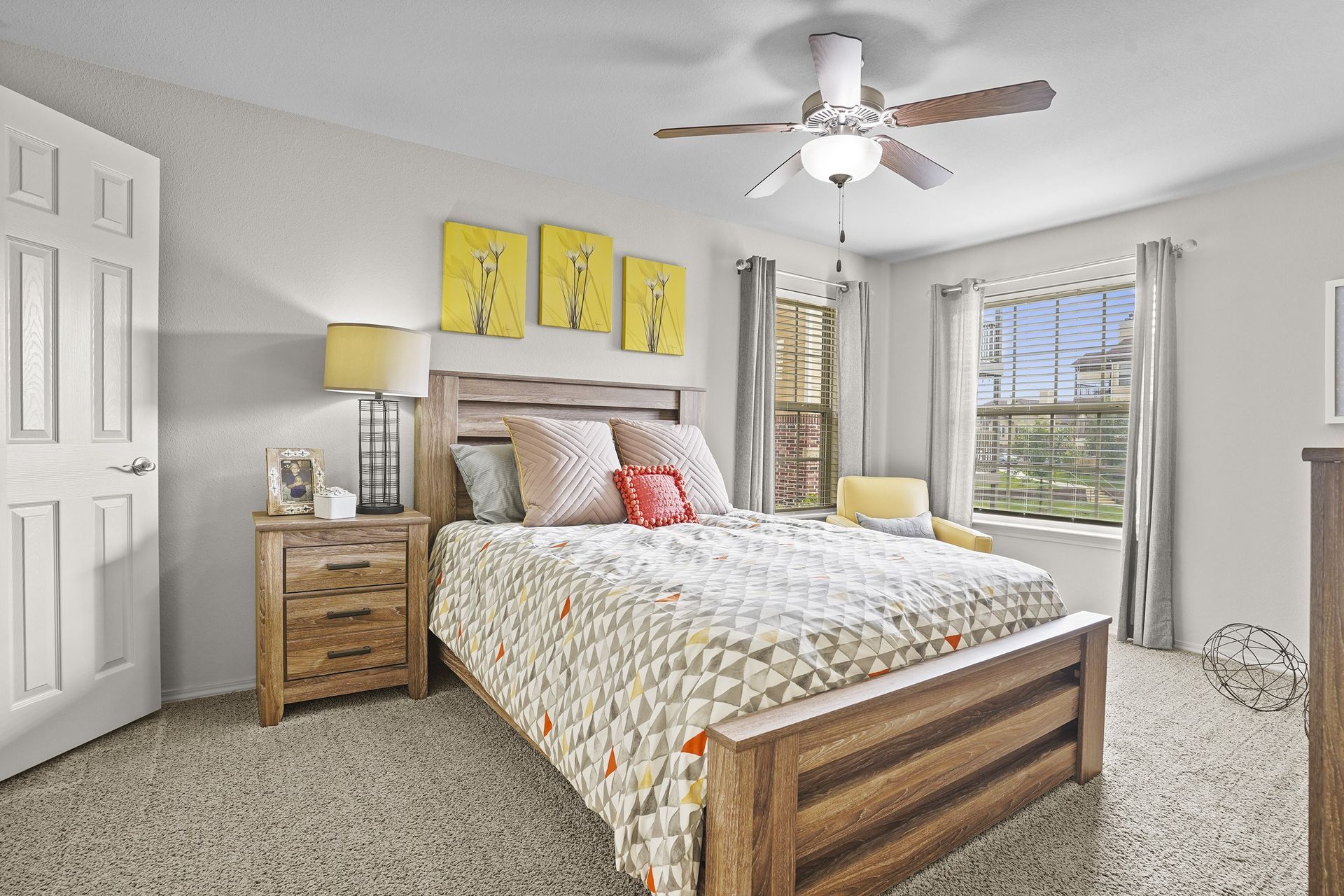A bedroom with a bed, nightstand, and a ceiling fan.