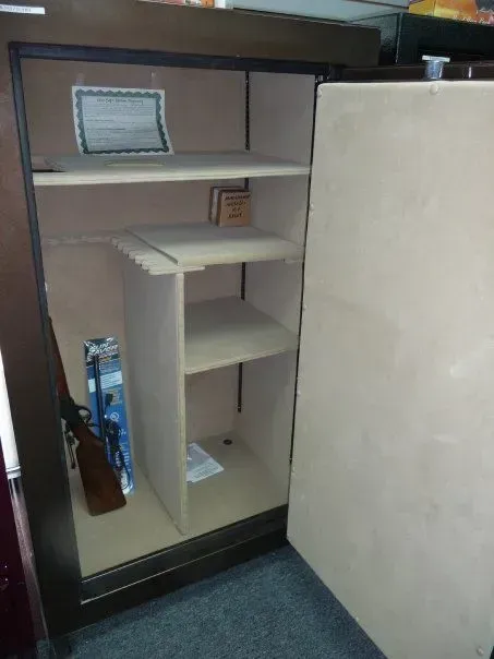 Open beige safe with three shelves.