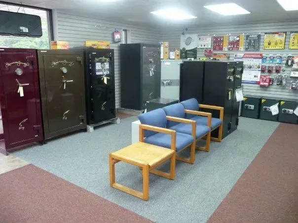 A store interior features several large safes against a wall, with display items above. 