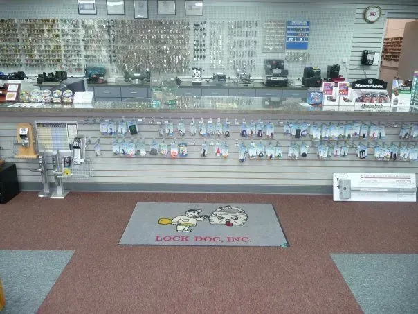 A locksmith shop interior with a counter displaying numerous key rings, lock products, and accessories.