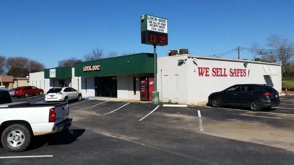 A white building with green trim features a sign reading 