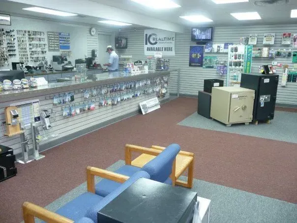 A well-lit security shop features a service counter with display racks of keys and merchandise. 