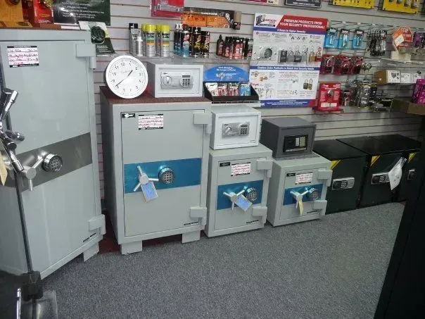 A display of various safes in a store, with different sizes and designs on a shelf.