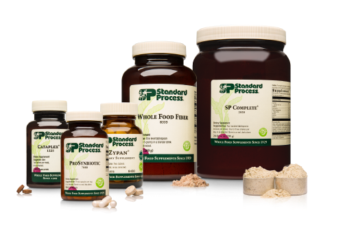 Bottles of Standard Process supplements: SP Complete powder, whole food, and pills.