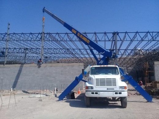 Un camión blanco con una grúa azul encima.