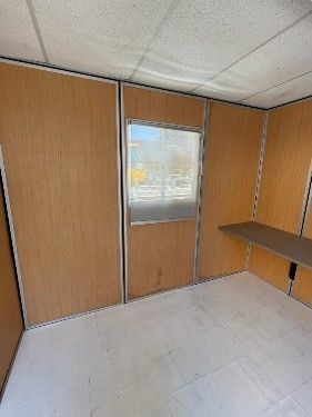 Una habitación vacía con paredes de madera y una ventana.