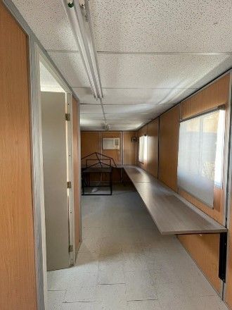 Un largo pasillo con una gran mesa de madera en el medio.