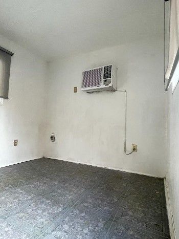 Una habitación vacía con un aire acondicionado de ventana en la pared.