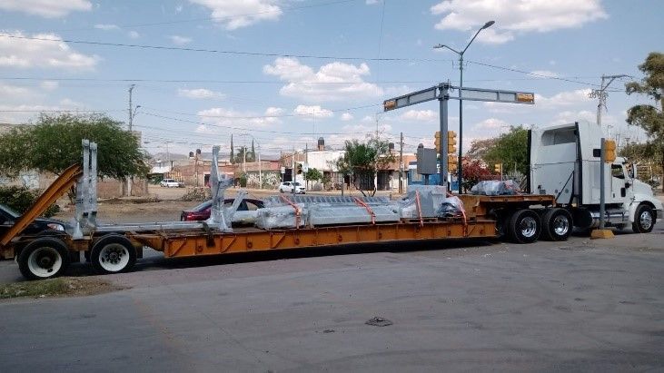 Un camión semirremolque transporta un objeto grande en un remolque.
