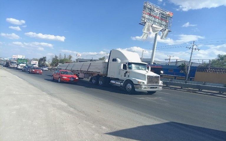 Un camión semirremolque blanco circula por una autopista.