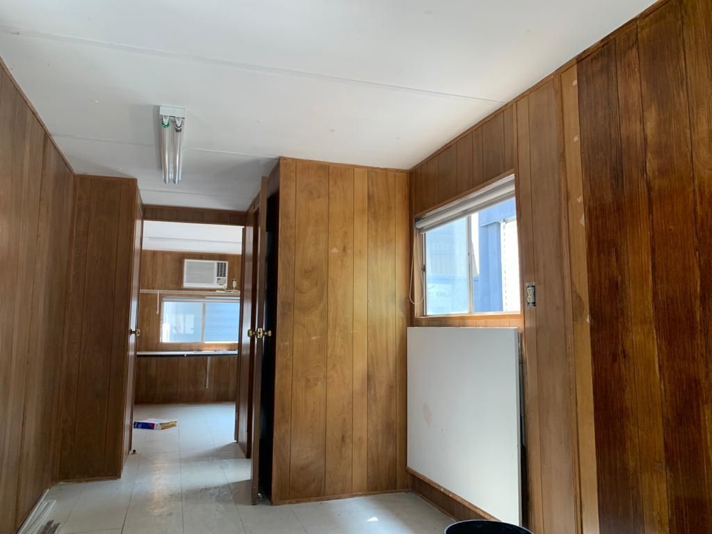 Un pasillo con paneles de madera y una ventana.