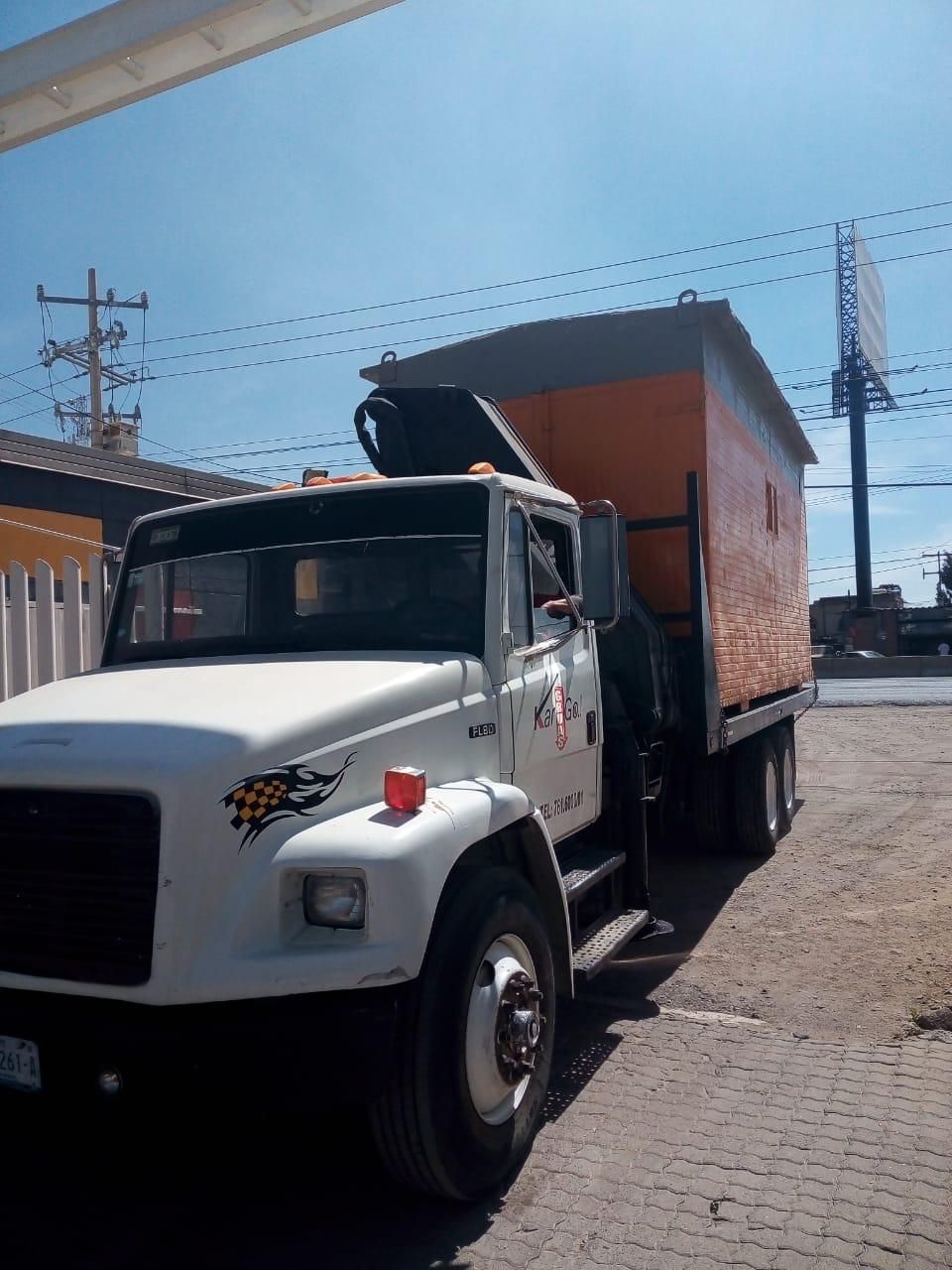Un camión blanco está estacionado frente a un edificio.
