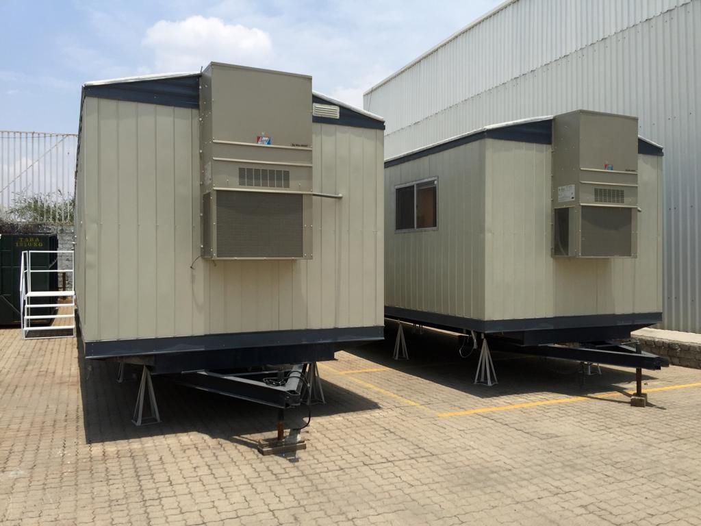 Dos remolques están estacionados uno al lado del otro en un estacionamiento.