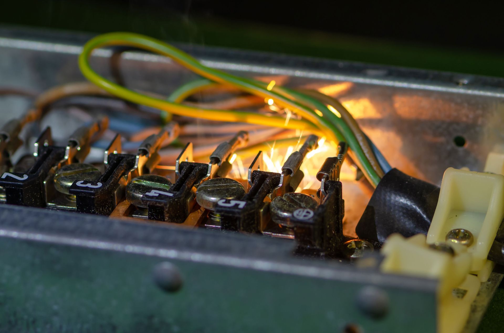 Close-up of glowing electrical components and wires inside a metal device корпус