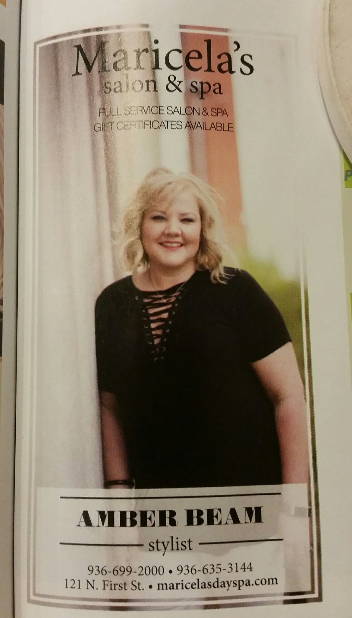 A woman is standing in front of a white curtain.