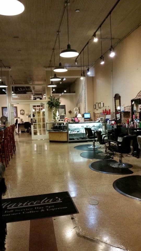 The inside of a hair salon with a black mat on the floor.