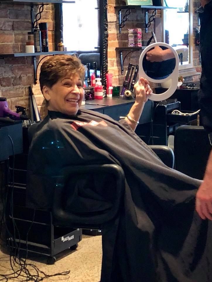 A woman is getting her hair cut at a salon