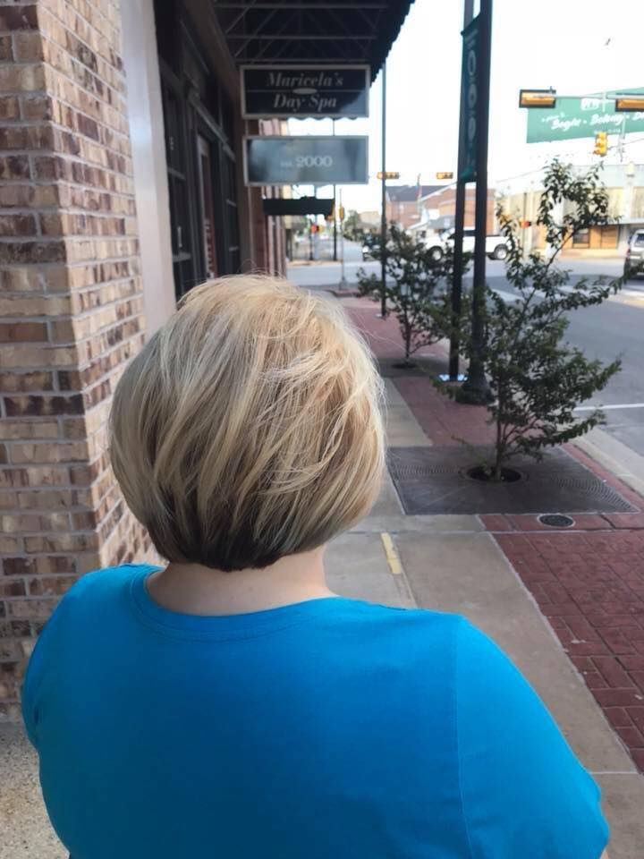 A woman in a blue shirt is walking down a sidewalk