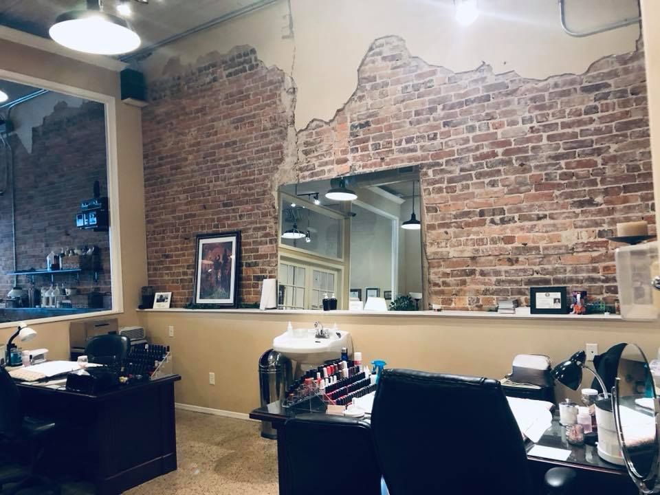 A salon with a brick wall and a large mirror.