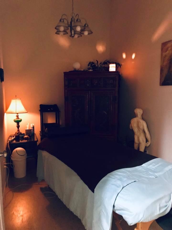 A room with a massage table and a lamp
