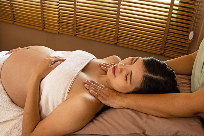 The therapiist hands massaging pregnant woman,for treat and relax program,at spa therapy.