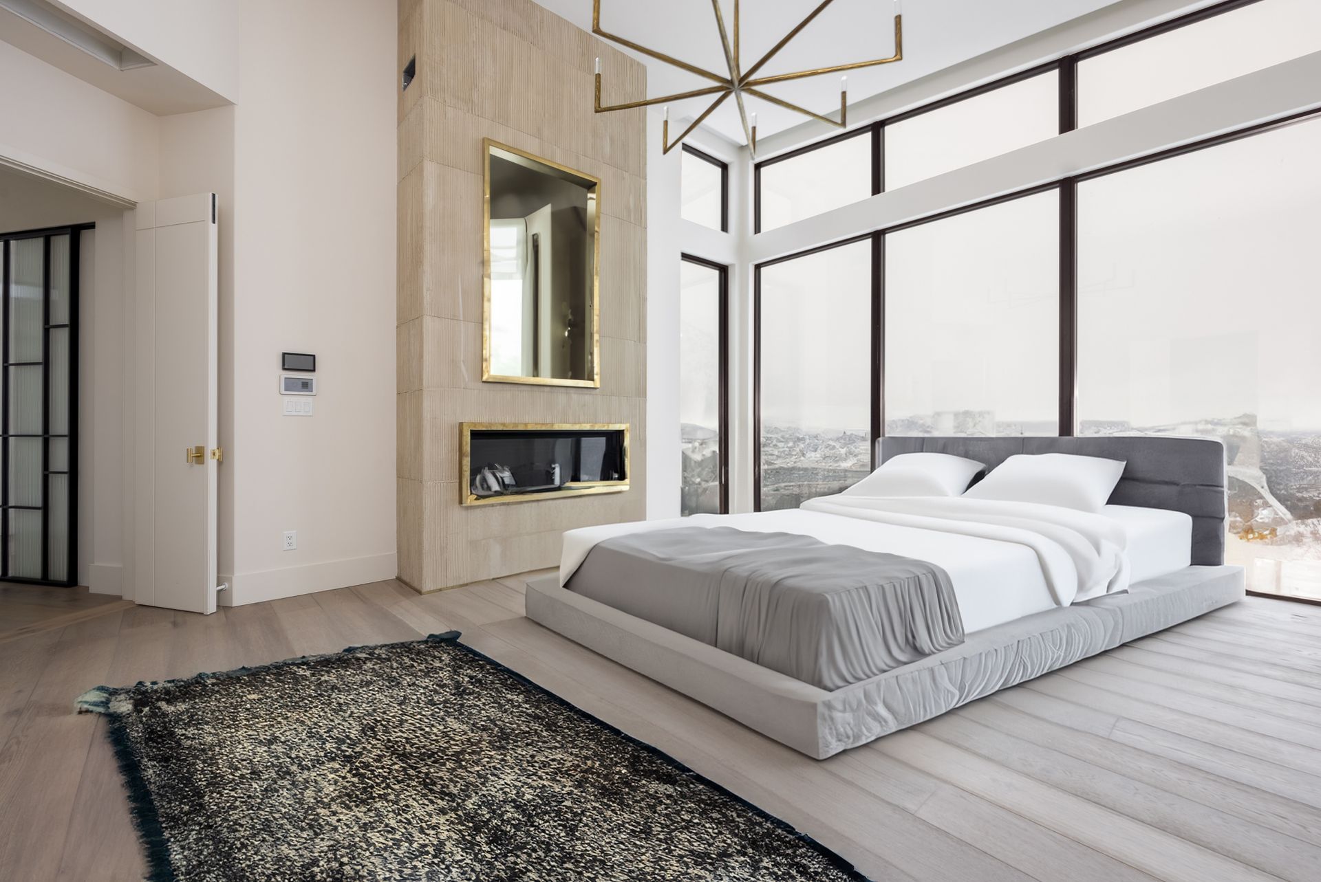 A bedroom with a large bed and a fireplace.