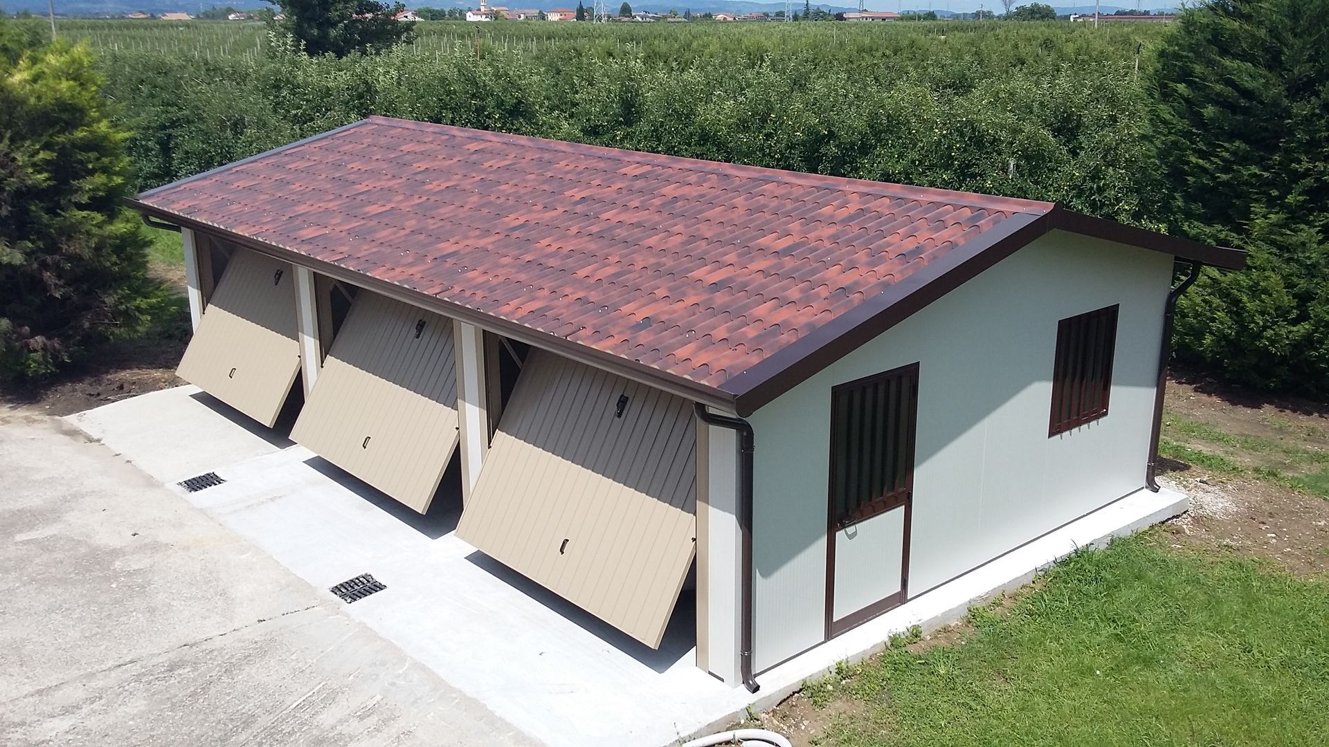 un garage bianco con due porte marroni e un tetto rosso