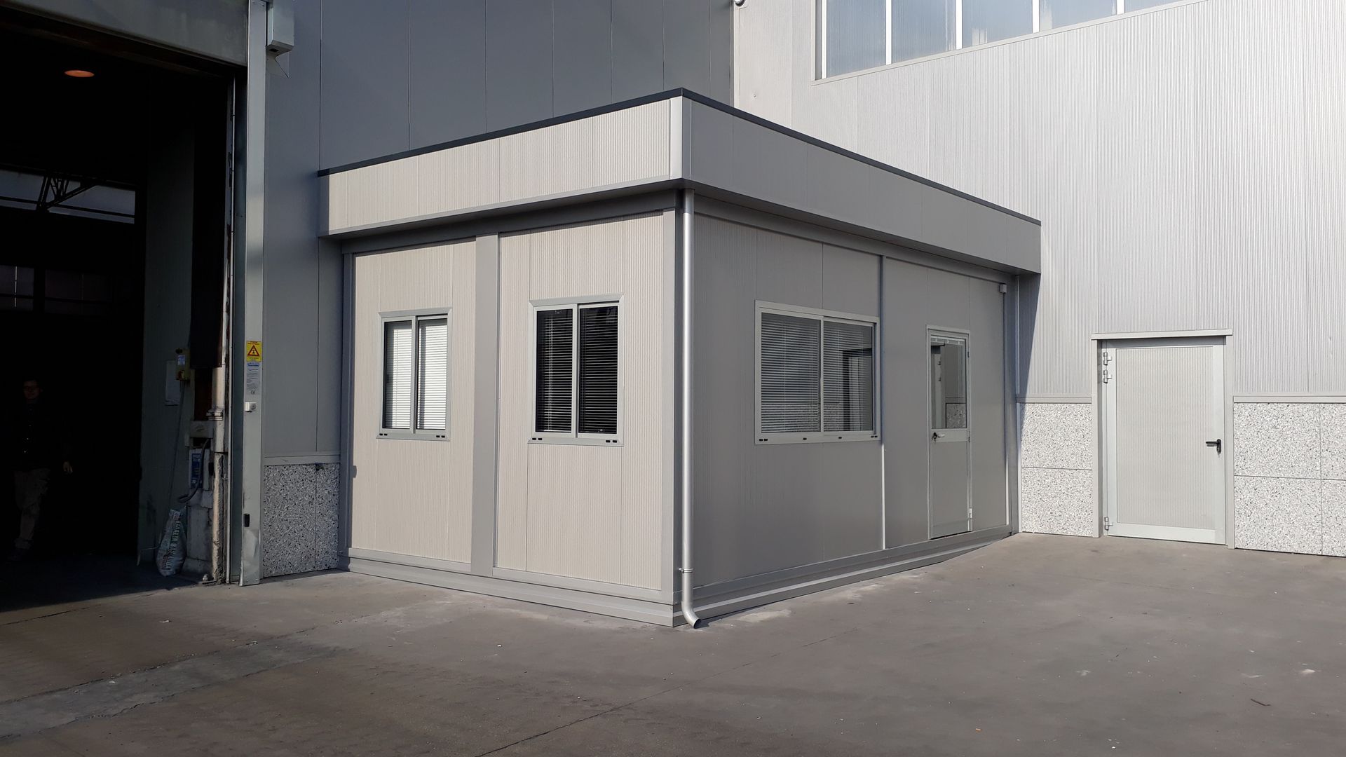 un piccolo edificio con molte finestre e una porta