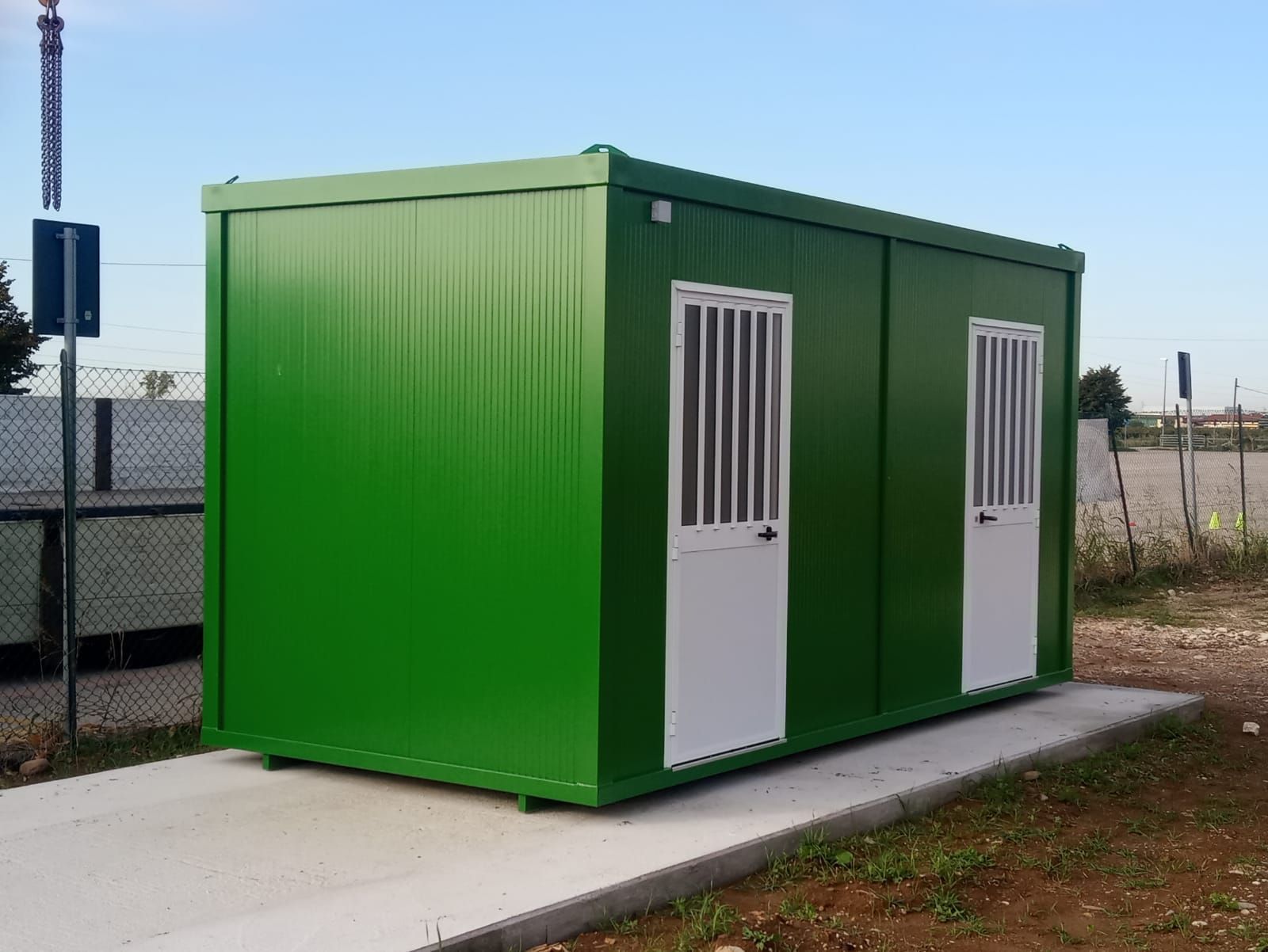 un edificio verde con due porte bianche