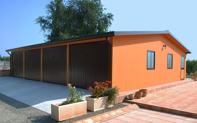 un grande garage arancione con porte marroni e molte finestre .