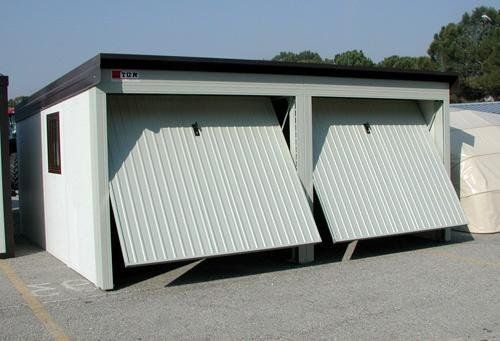 un garage bianco con le porte aperte in un parcheggio .
