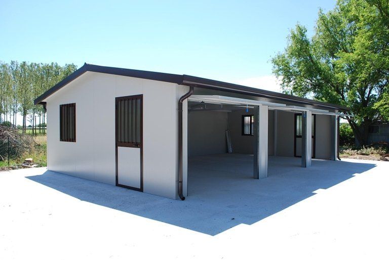 un garage bianco con un tetto marrone e due porte