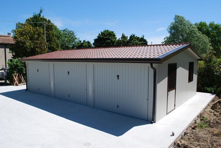 un garage con tre porte e un tetto marrone .