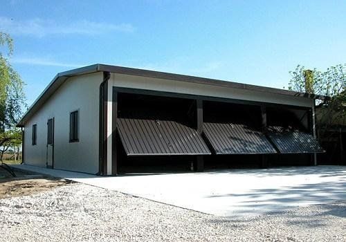 un garage con tre porte scorrevoli bianche e una porta marrone .