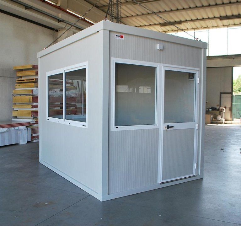 una piccola cabina bianca con due finestre e una porta