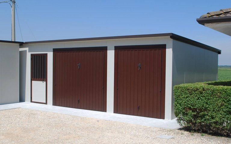 un garage con due porte marroni e una porta bianca