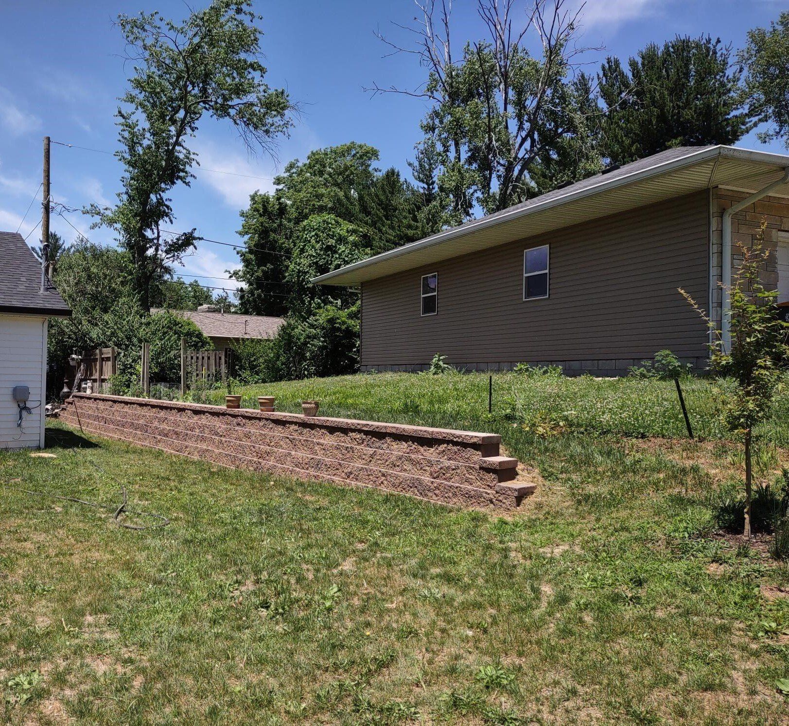 A house sits in the middle of a lush green field
