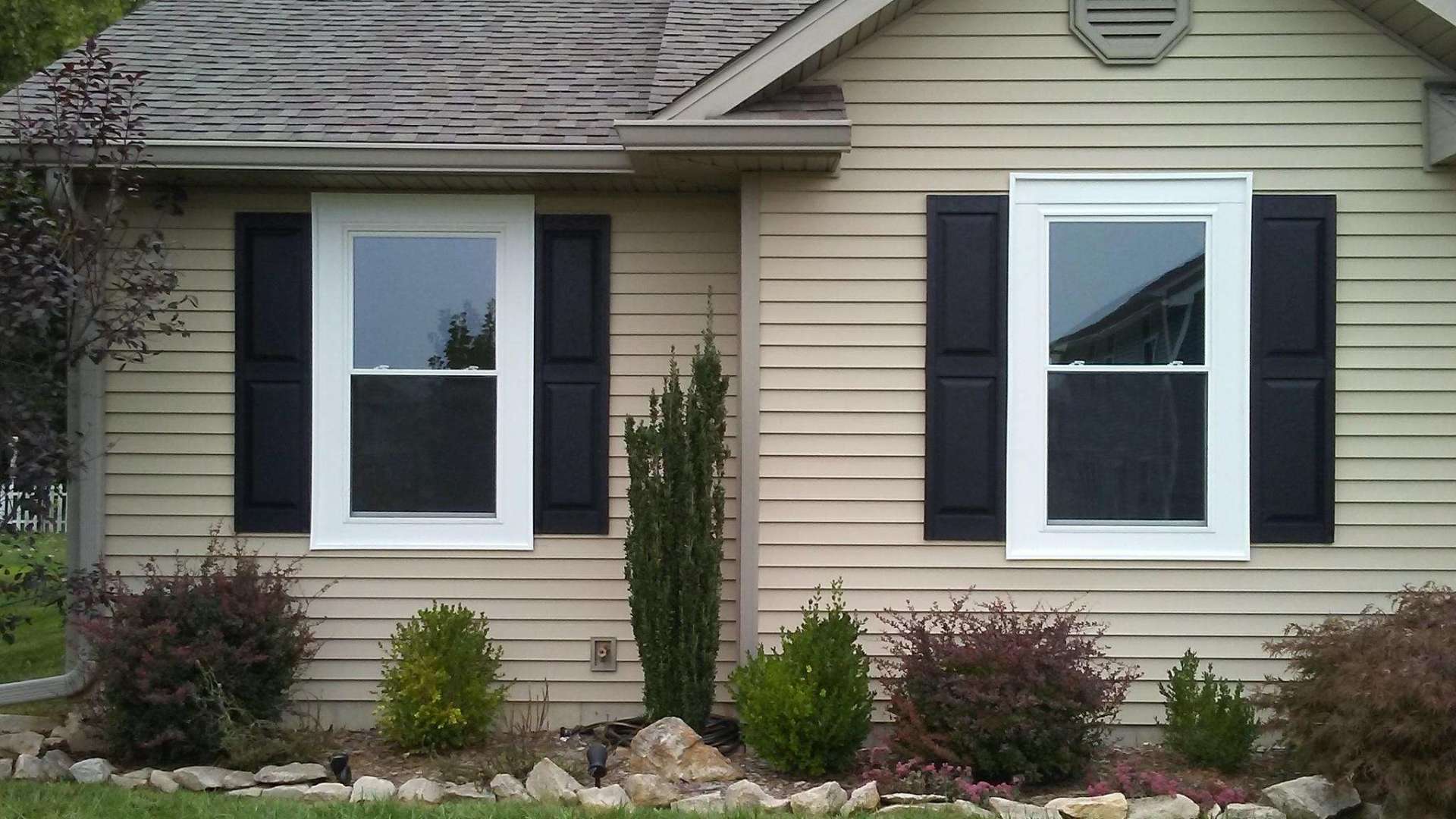 A house with black shutters and white windows