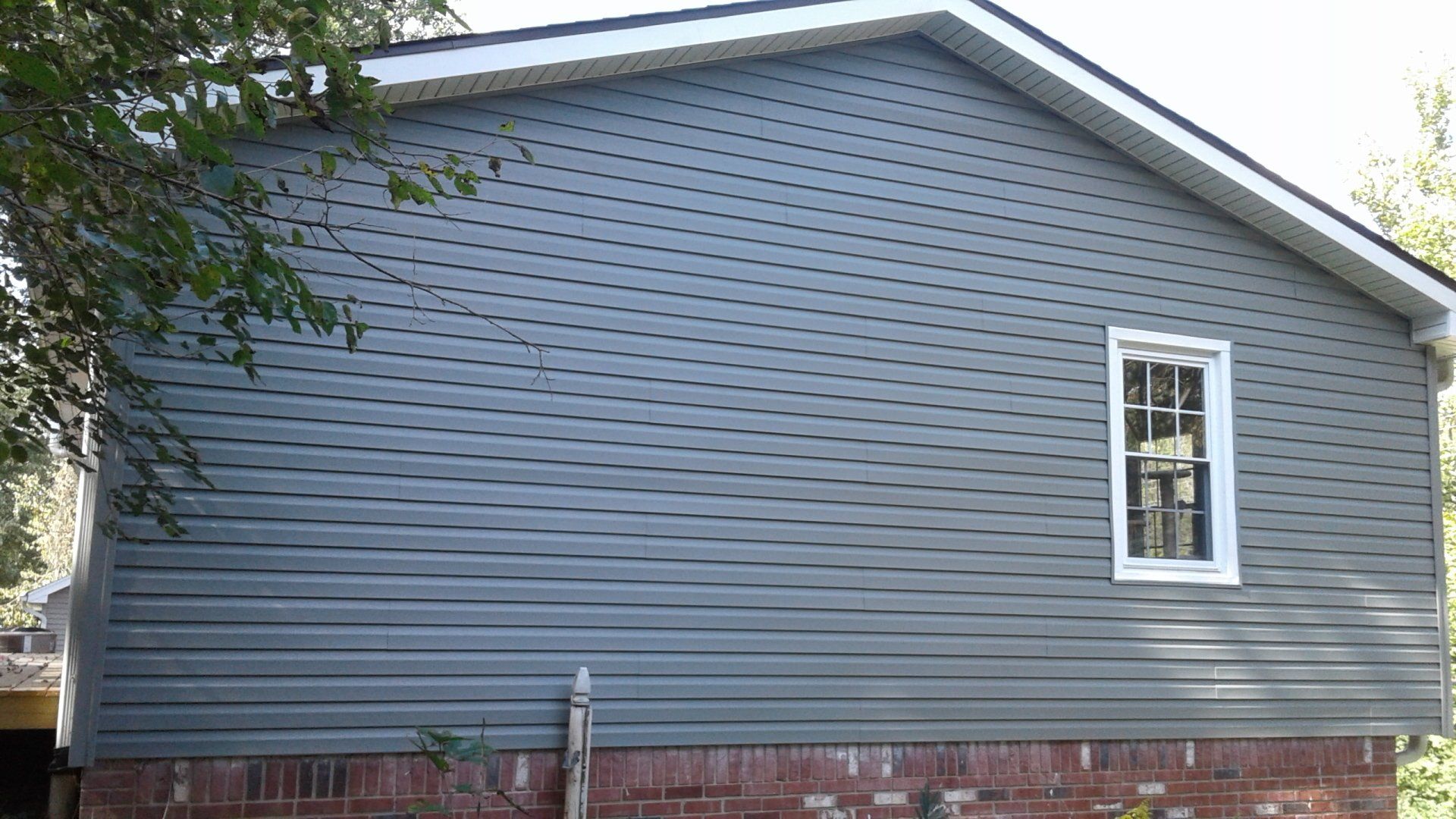 A house with a gray siding and a white window.
