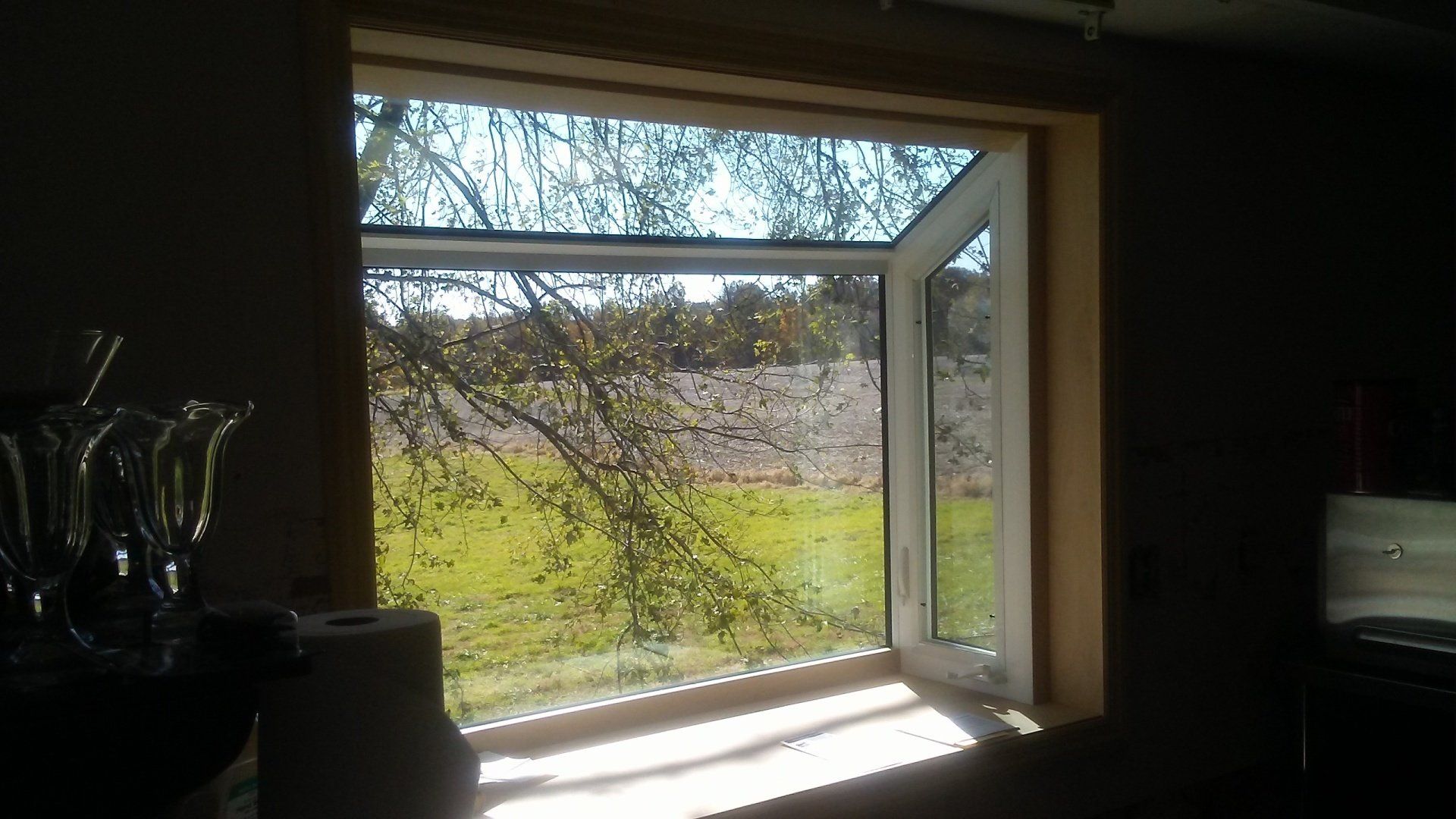 A large window in a room with a view of a field.