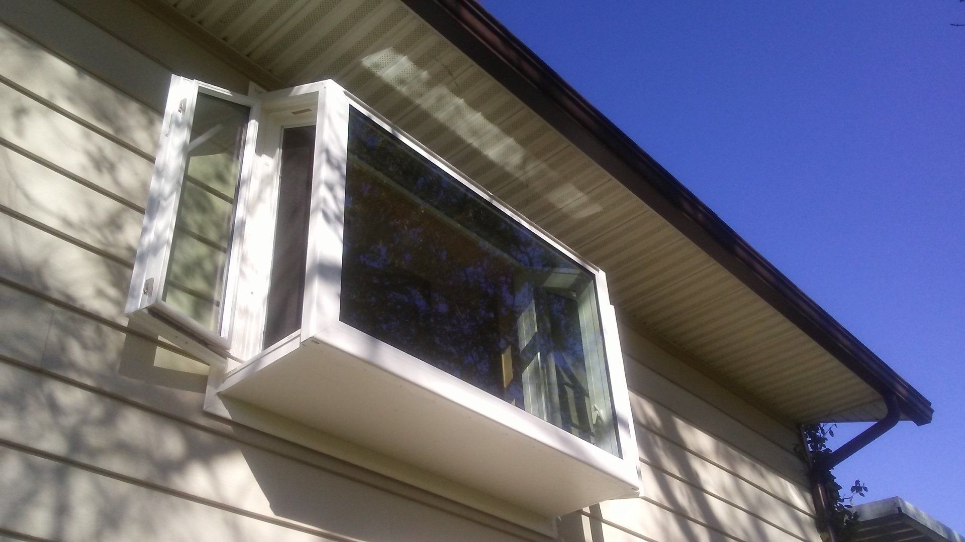 A window on the side of a house that is open