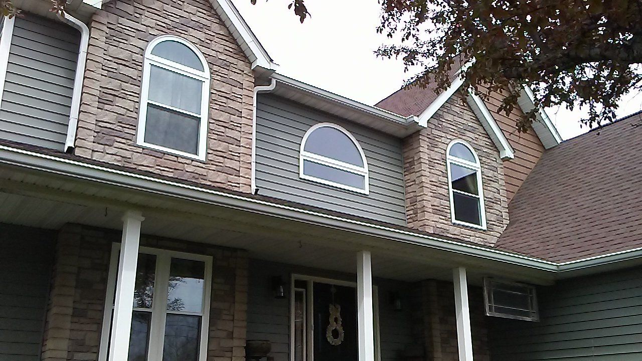 A large brick house with arched windows and a porch