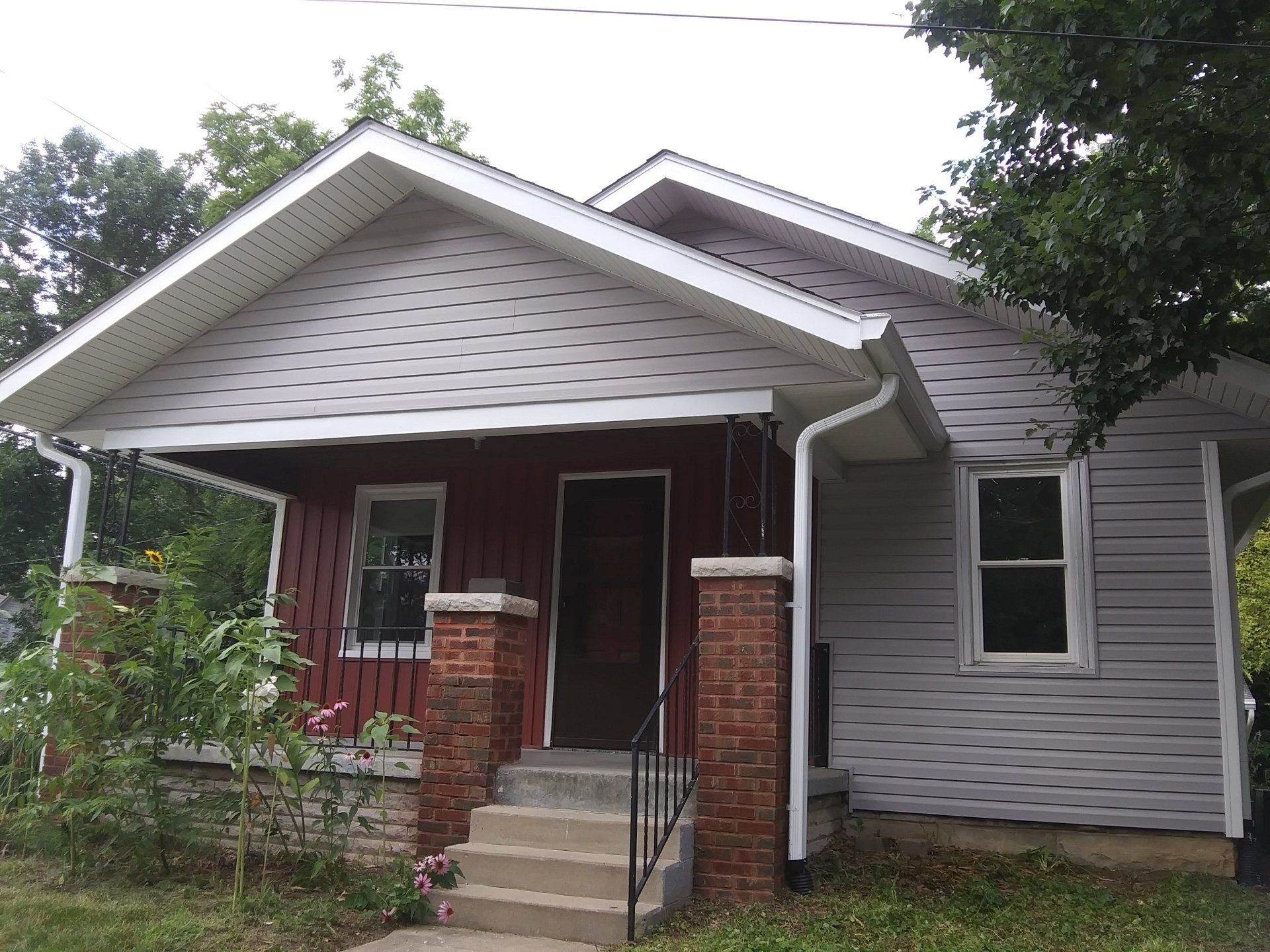 A small red and white house with a porch and stairs