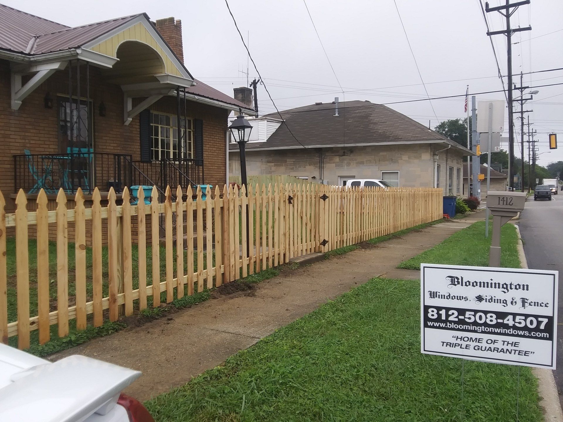 A wooden picket fence along the side of a street
