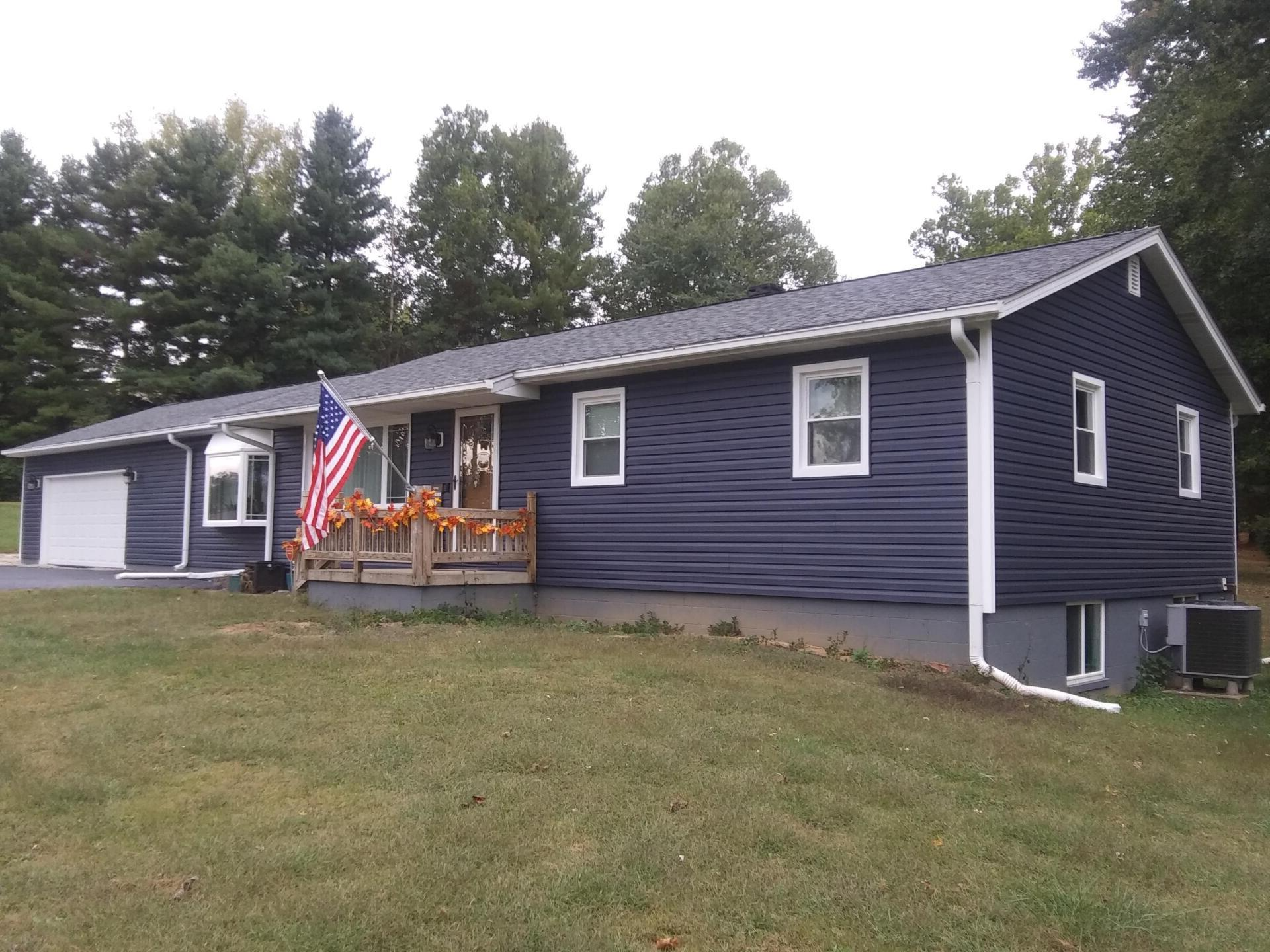 A blue house with an american flag on the porch