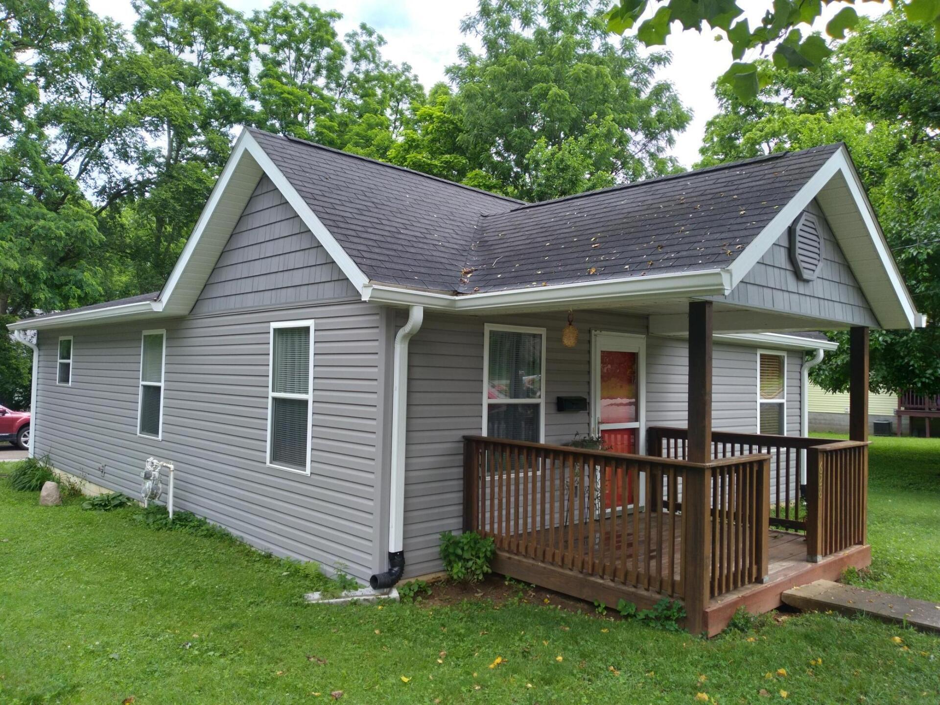 A small house with a porch and a roof