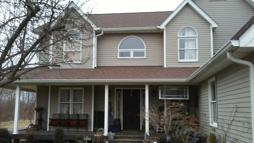 The front of a house with a porch and a red roof